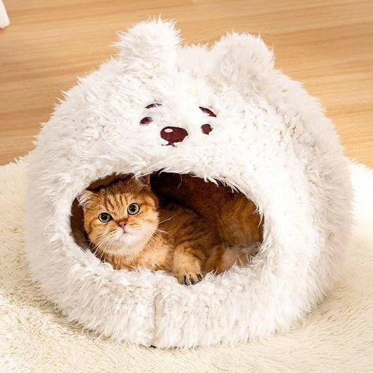 Fluffy white bear covered pet cave bed with ginger cat lounging inside