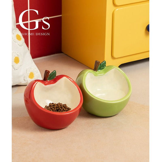 Red and green Honeycrisp ceramic apple shaped pet bowls sitting side by side filled with cat food